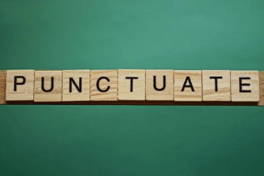 Gri kelime yeşil bir masadaki küçük tahta harflerden noktalanıyor.