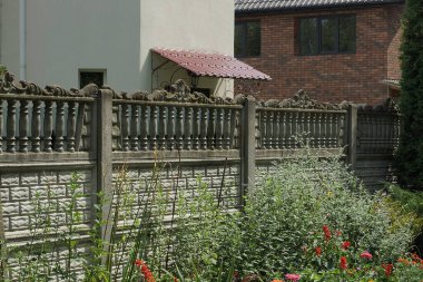 Gri beton bir duvarın bir parçası. Sokakta yeşil çimenler içinde.