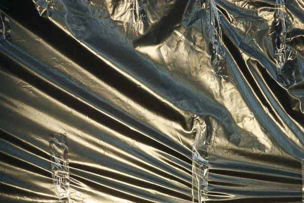 plastic texture of black cellophane on a old crumpled bag