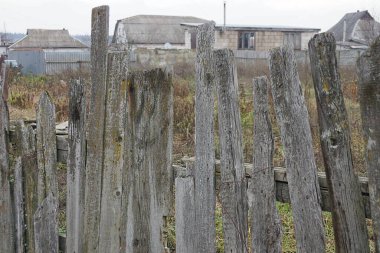  Kırsal bir sokakta kırık tahtaları olan eski bir ahşap çitin parçası.