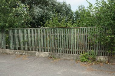 Caddedeki tahtalardan eski, uzun, gri, ahşap çitler. 