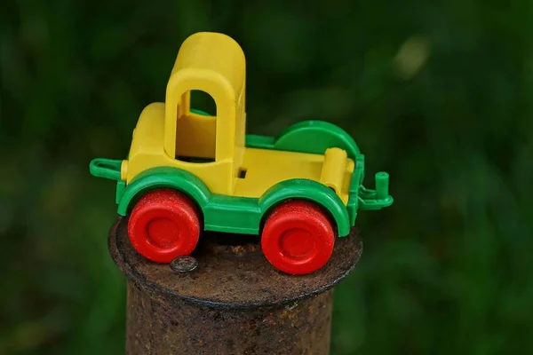 Jeden Mały Plastikowy Samochód Zabawki Stoi Brązowym Zardzewiałym Słupie Żelaza — Zdjęcie stockowe