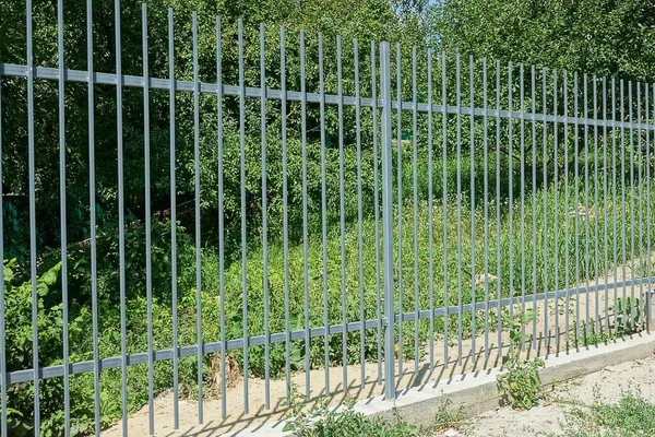 街上的混凝土地基上的铁栅栏的灰色金属墙 — 图库照片