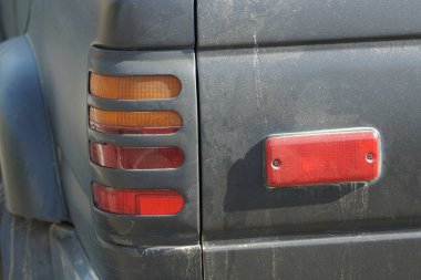 Arabanın siyah metalinde kırmızı far ve plastik yansıtıcı.