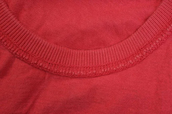 red background of fabric from a piece of cloth with a seam