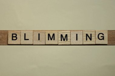 Kahverengi arkaplandaki ahşap kare harflerden oluşan gri kelime.