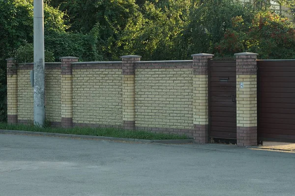 Kapalı Demir Kapılı Uzun Kahverengi Tuğlalı Duvarlar — Stok fotoğraf