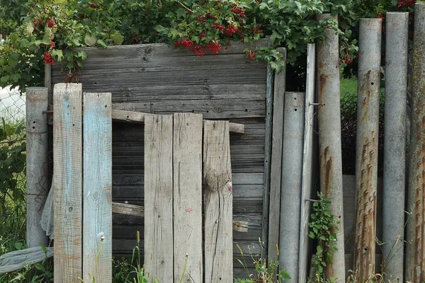 Část Staré Šedé Stěny Plotu Polámaných Dřevěných Prken Kovovými Trubkami — Stock fotografie