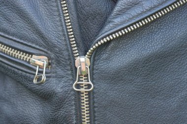 İki metal beyaz gri, eski siyah deri ceketin fermuarı kapalı.