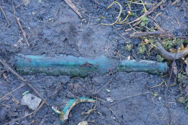 garbage from one dirty old glass green bottle lies on the gray ground on the street