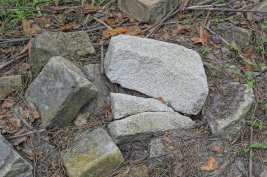 Gri zeminde kırılan tuğlalardan oluşan bir yığın.