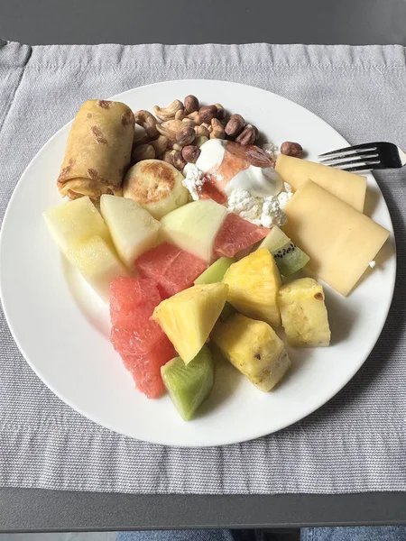 Lokantada kahvaltı taze meyve ve sebzelerle krep ve diyet yemekle masada beyaz bir tabakta.