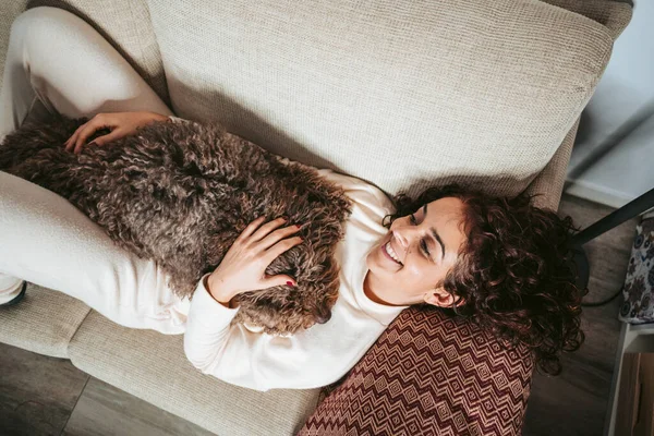 Een Mooie Vrouw Liggend Bank Met Haar Spaanse Waterhond Genietend — Stockfoto