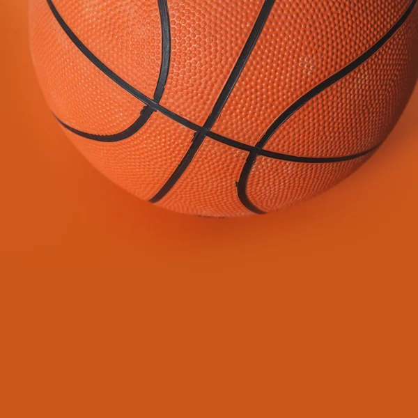 Kosárlabda a narancssárga háttérrel — Stock Fotó