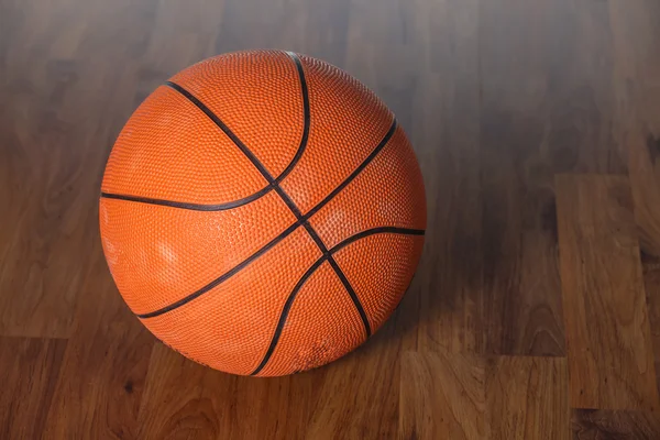 Bola de basquete sobre piso de madeira — Fotografia de Stock