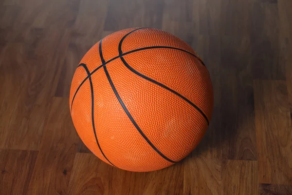 Bola de basquete sobre piso de madeira — Fotografia de Stock