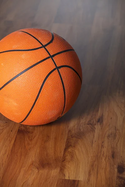 Bola de basquete sobre piso de madeira — Fotografia de Stock