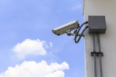 Mavi gökyüzü arkaplanındaki güvenlik kamerası 