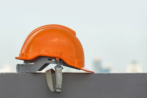 Safety helmet and goggles with construction site in the background — Stock Photo, Image