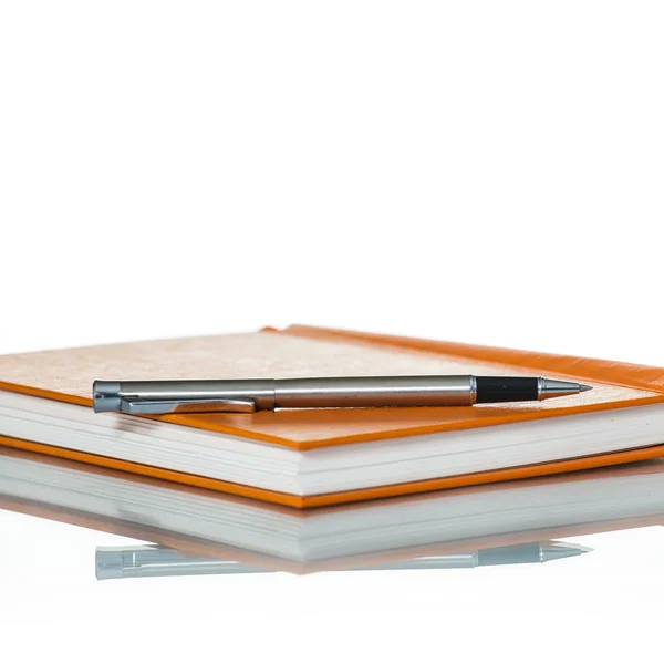 Ноутбук и ручка на белом фоне — стоковое фото