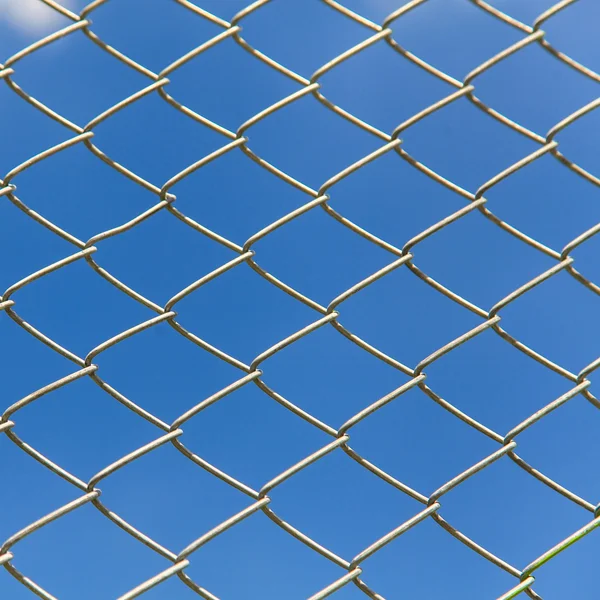 Valla alambrada sobre fondo azul del cielo —  Fotos de Stock