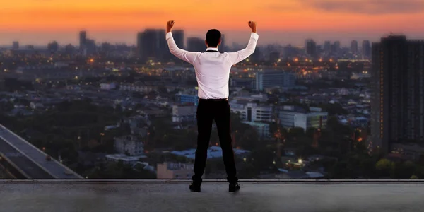 领导观念 商业上的成功取得了成果 商人站在屋顶上 日落时凝视着城市的地平线 — 图库照片
