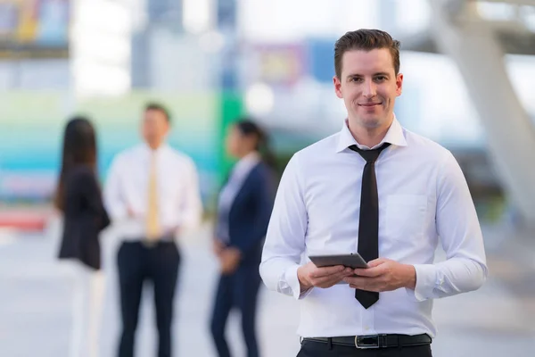 Empresario Pie Con Uso Una Tableta Digital Pie Frente Los —  Fotos de Stock