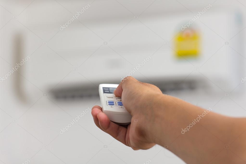 Hand turning on air conditioning — Stock Photo © Naypong 54517309
