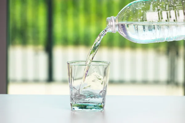 Pouring water on glass — Stock Photo, Image