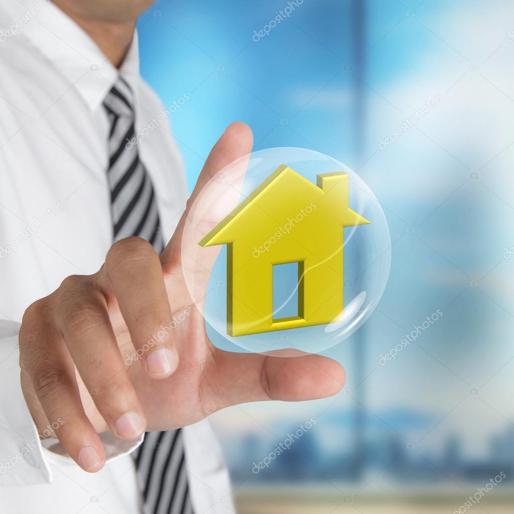 Hand holding bubble with home sign 