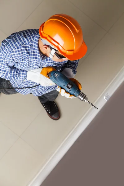 Builder or worker drilling with a machine or drill — Stock Photo, Image