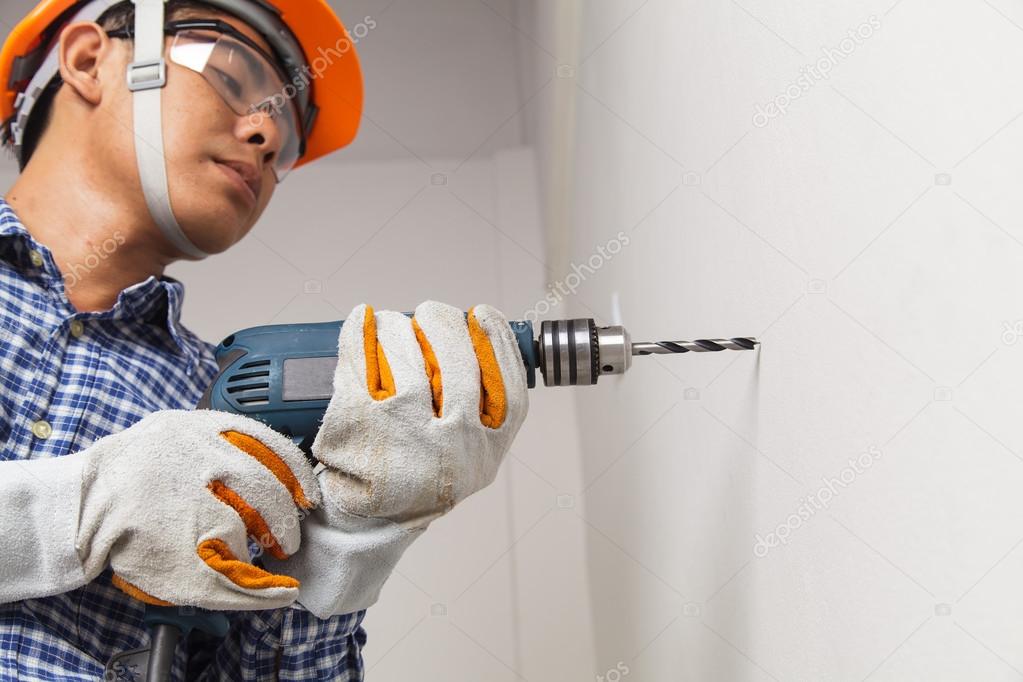 Builder or worker drilling with a machine or drill