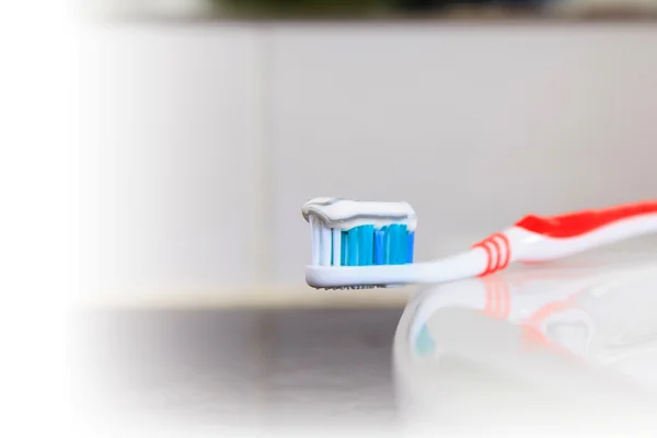 Zahnbürste mit Zahnpasta im Waschbecken — Stockfoto