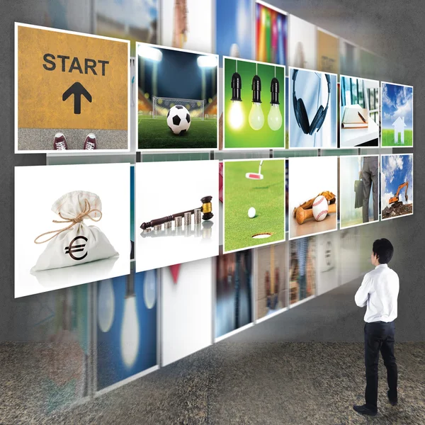 Businessman standing looking at TV screen — Stock Photo, Image