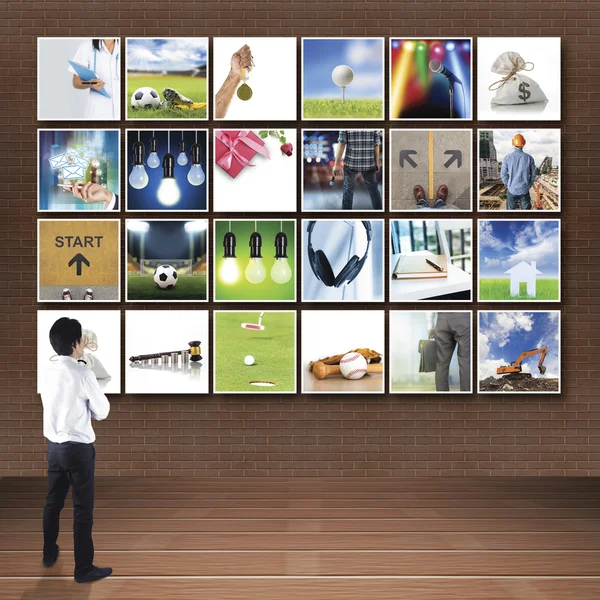 Businessman standing looking at photo gallery images — Stock Photo, Image