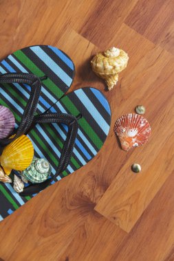 Ahşap arka plan üzerinde seashell ile terlik