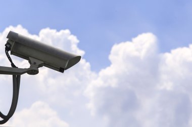 Mavi gökyüzü arkaplanındaki güvenlik kamerası
