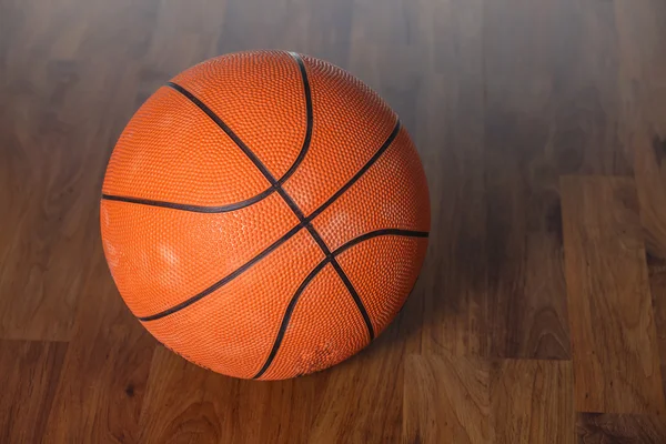 Баскетбольний м'яч над дерев'яною підлогою — стокове фото