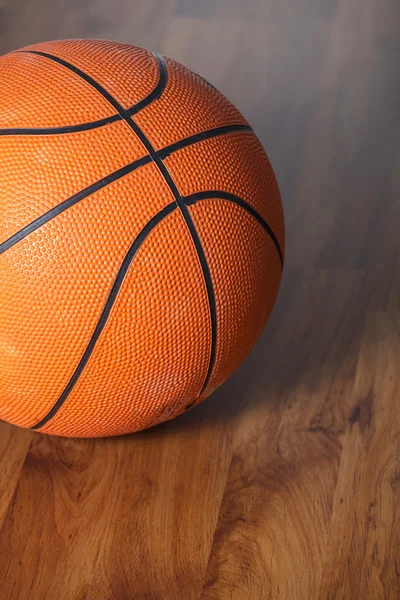 Bola de basquete sobre piso de madeira — Fotografia de Stock