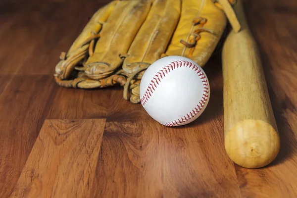 Bate de béisbol con bola y guante de béisbol sobre fondo de madera — Foto de Stock