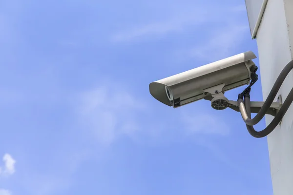 Beveiligingscamera op blauwe lucht achtergrond — Stockfoto