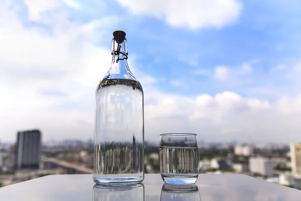 Masaya bir şişe ile su — Stok fotoğraf