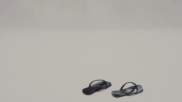 Тапочки на пляже — стоковое фото