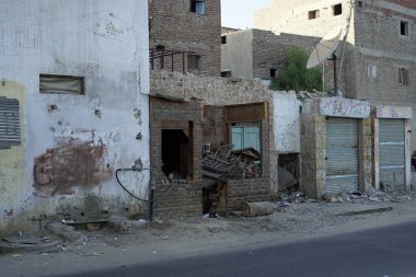 Mısır 'da yıkılan çok katlı binalar arasındaki dar, kirli toprak yol