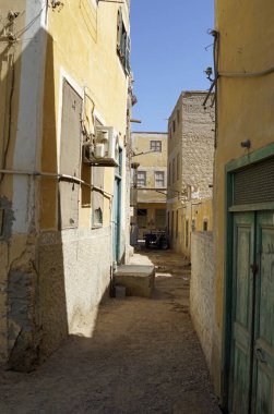 Mısır 'da yıkılan çok katlı binalar arasındaki dar, kirli toprak yol