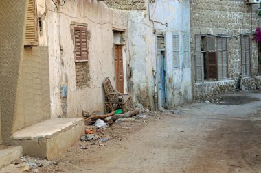 Mısır 'da yıkılan çok katlı binalar arasındaki dar, kirli toprak yol