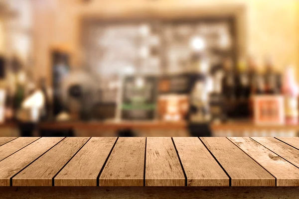 Wooden table with a view of blurred beverages bar backdrop — Stock Photo, Image