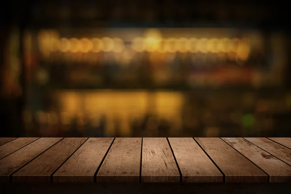 Mesa de madera con una vista de bebidas borrosas bar telón de fondo —  Fotos de Stock