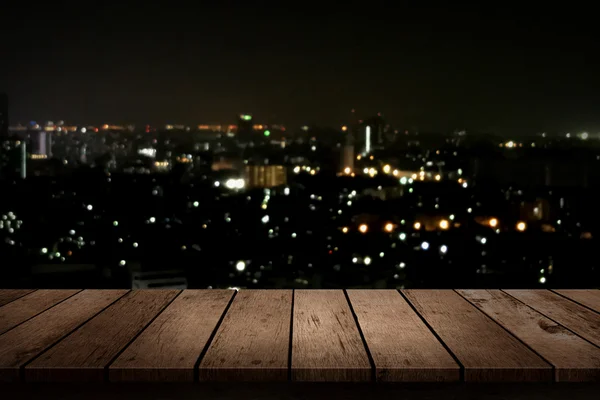 Dessus de table en bois sur fond nuit ville — Photo