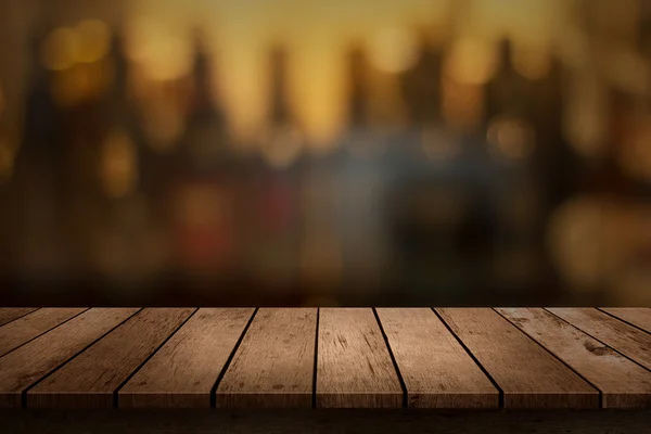 Mesa de madera con una vista de bebidas borrosas bar telón de fondo —  Fotos de Stock